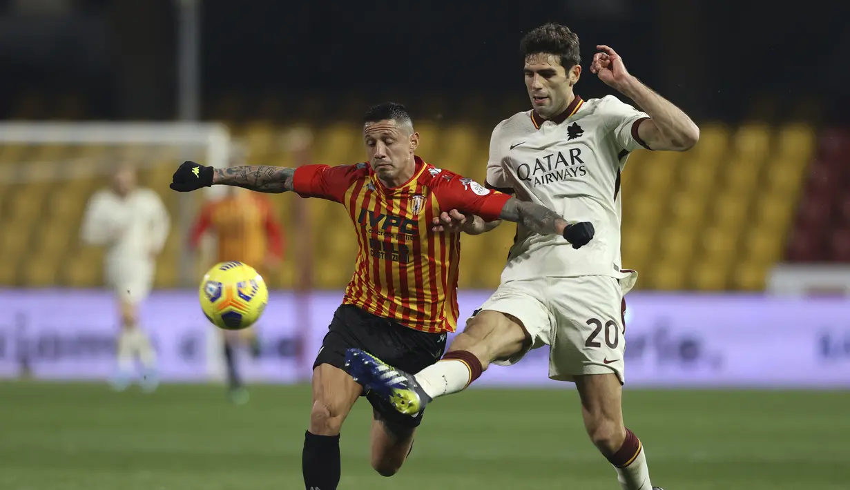 Penyerang Benevento, Gianluca Lapadula dan bek AS, Roma Federico Fazio bersaing memperebutkan bola dalam lanjutan Liga Italia di Stadio Ciro Vigorito, Senin (22/2/2021) dini hari WIB.  AS Roma  ditahan imbang 0-0 kala melawat ke Benevento. (Alessandro Garofalo/LaPresse via AP)