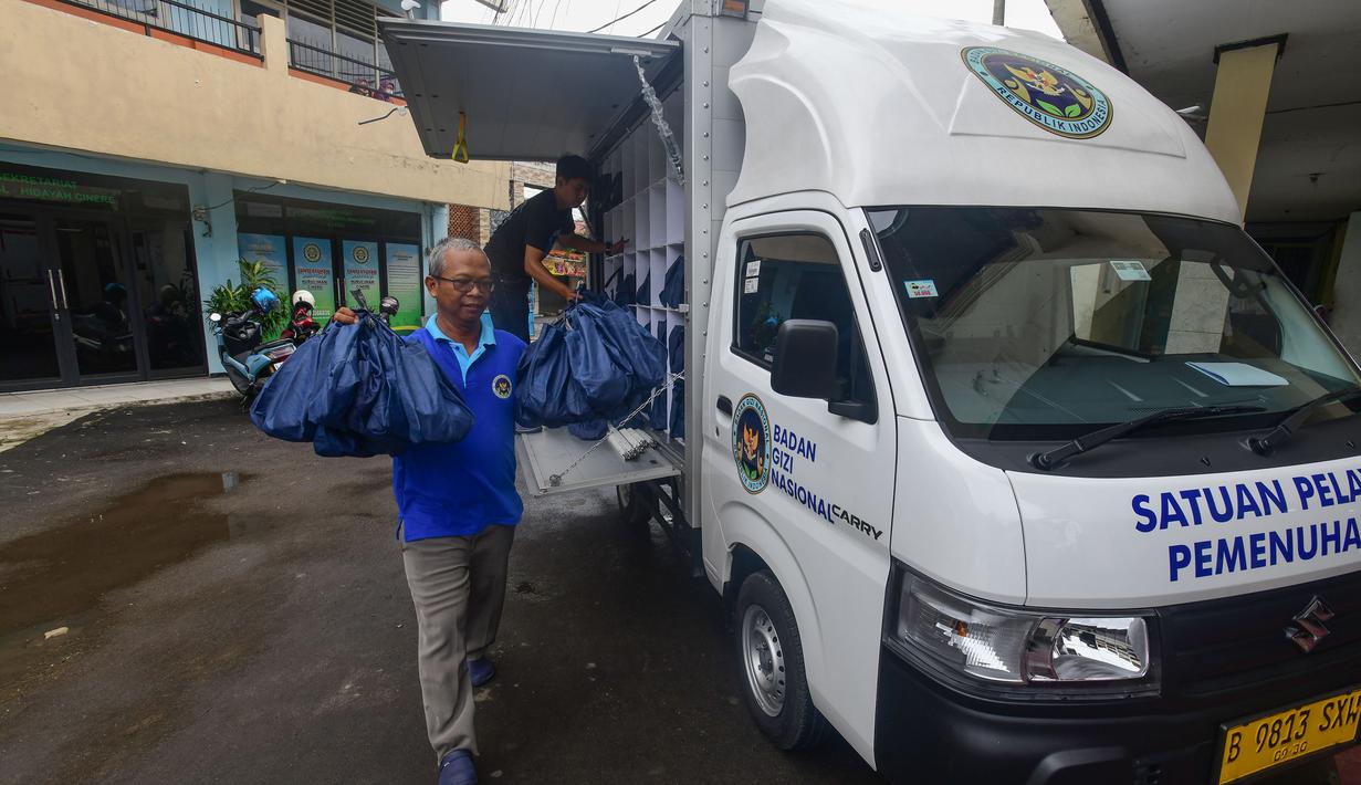 Petugas Satuan Pelayanan Pemenuhan Gizi (SPPG) saat mendistribusikan makanan program Makan Bergizi Gratis (MBG) Ramadan di SDI Al Hidayah, Cinere, Depok, Selasa (24/2/2026). Program Makan Bergizi Gratis (MBG) tetap berjalan selama bulan Ramadan 2026 (1447 H). (merdeka.com/Arie Basuki)