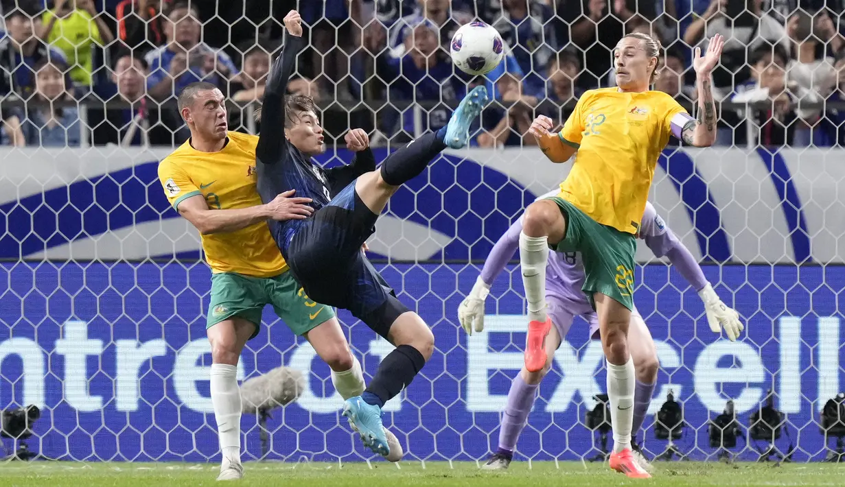 Pemain Jepang, Ayase Ueda (tengah) berebut bola dengan dua pemain Australia, Lewis Miller (kiri) dan Jackson Irvine saat laga lanjutan Grup C Kualifikasi Piala Dunia 2026 melawan Australia di Saitama Stadium, Jepang, Selasa (15/10/2024). (AP Photo/Eugene Hoshiko)