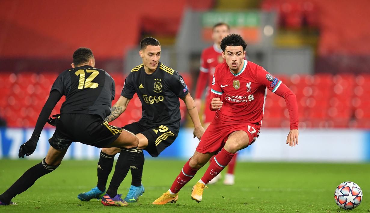 Gelandang Liverpool, Curtis Jones (kanan), melepaskan diri dari penjagaan dua pemain Ajax Amsterdam dalam laga lanjutan Liga Champions 2020/21 Grup D di Anfield Stadium, Liverpool, Selasa (1/12/2020) waktu setempat. Liverpool menang 1-0 atas Ajax. (AFP/Paul Ellis/Pool)
