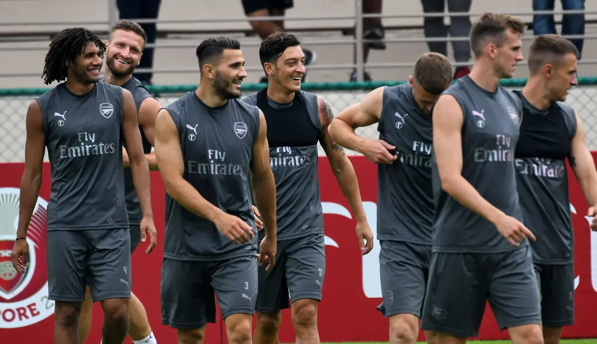 Keceriaan Mesut Ozil dan pemain Arsenal lainnya saat sesi latihan untuk kompetisi pramusim International Champions Cup (ICC) 2018 di Singapura, Rabu (27/5). Menjelang duel kontra Atletico Madrid, Ozil dkk menikmati sesi latihan ringan. (AFP/Roslan RAHMAN)