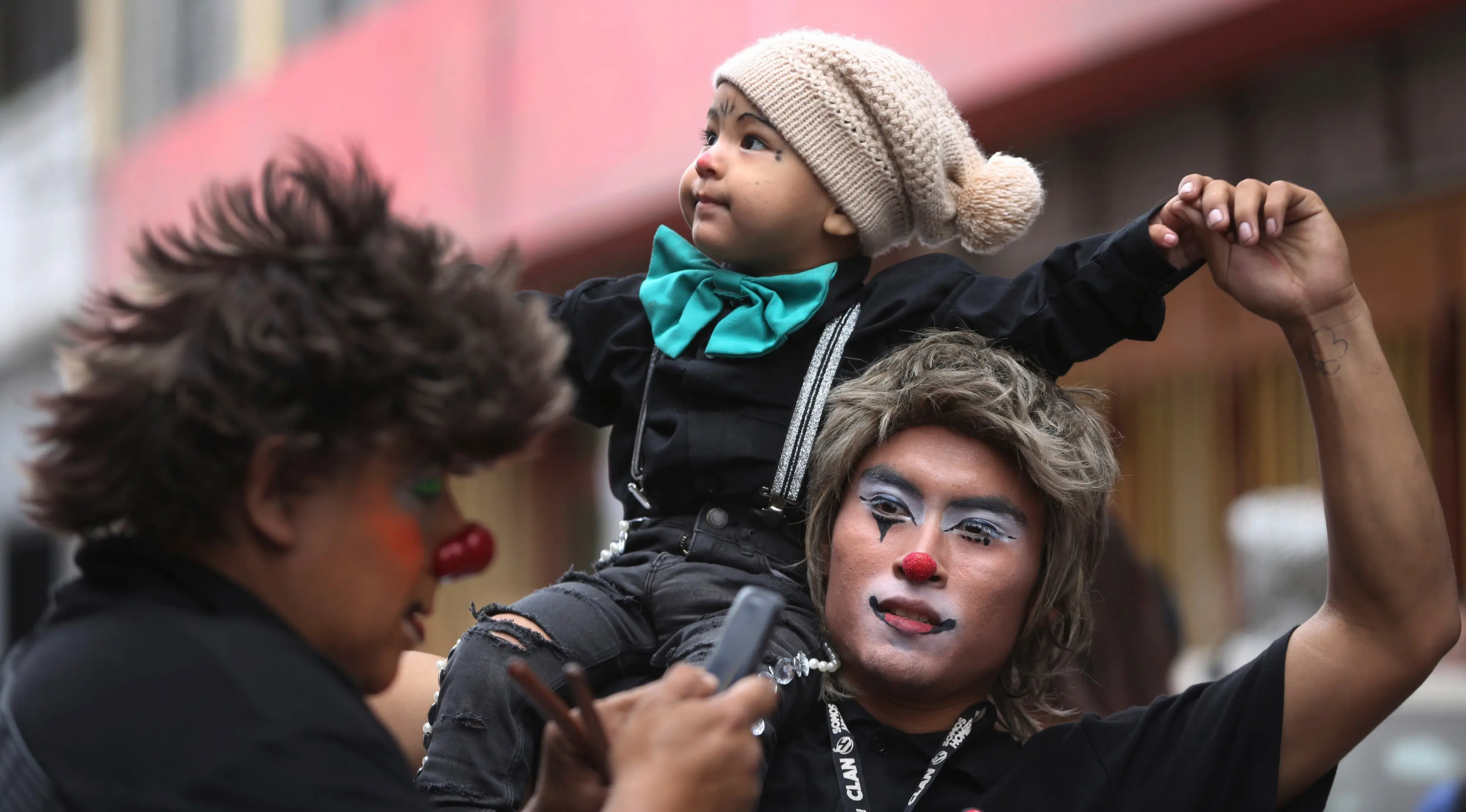 Seorang badut menggendong anaknya di atas bahu saat berpartisipasi dalam acara Hari Badut Nasional di ibu kota Peru, Lima, Kamis(25/5). Tanggal 25 Mei merupakan peringatan Hari Badut Nasional bagi warga Peru. (AP Photo/Martin Mejia)