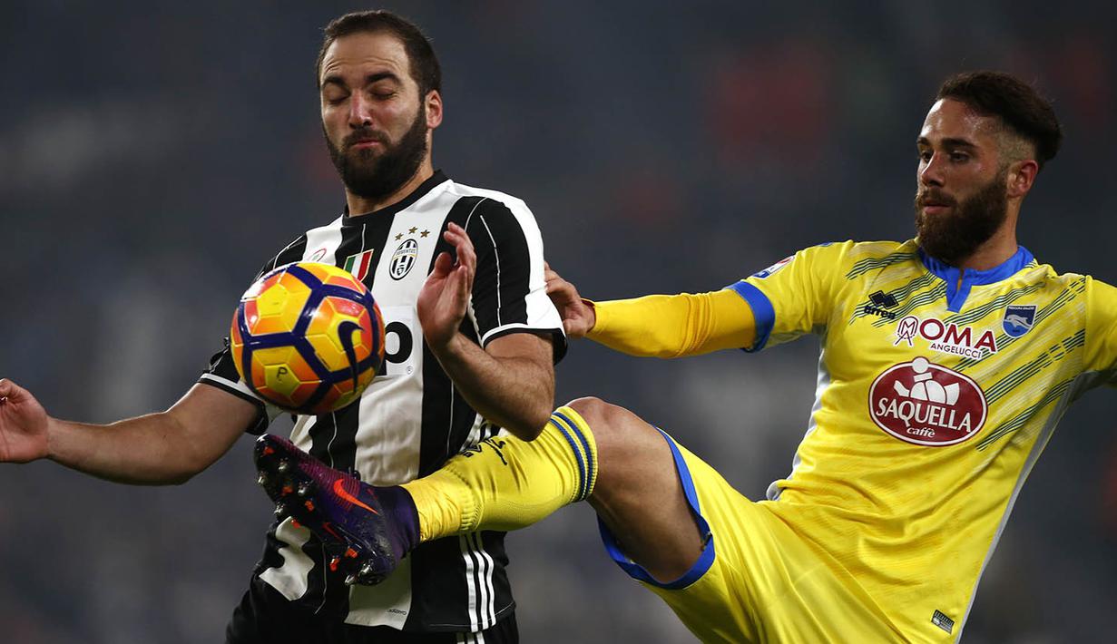 Striker Juventus, Gonzalo Higuain, berebut bola dengan bek Pescara, Francesco Zampano. Pada laga ini Juve menguasai jalannya laga dengan penguasaan bola 62 persen. (AFP/Marco Bertorello)
