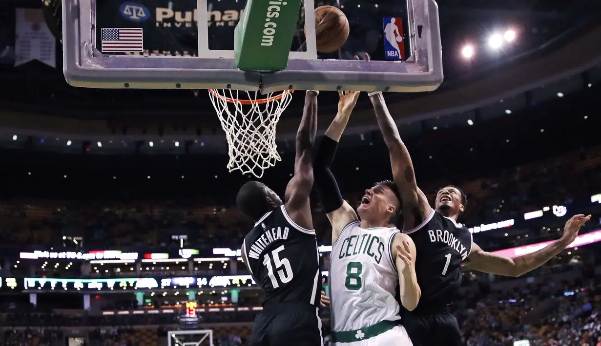 Pemain Boston Celtics, Jonas Jerebko (tengah) dihimpit dua pemain Brooklyn Nets pada laga NBA preseason basketball game, Boston, Selasa (18/10/2016) WIB. Celtics menang atas Nets 120-99. (AP/Charles Krupa)