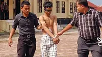 Satu dari delapan teroris yang ditangkap dalam kontak senjata di Leupung, Kabupaten Aceh Besar dikawal polisi saat tiba di Mapolda Aceh.(Antara)