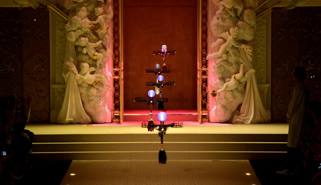 Deretan pesawat tanpa awak (drone) membawa koleksi tas tangan Dolce & Gabbana pada Milan Fashion Week 2018, Minggu (25/). Drone ini keluar dari belakang panggung, lalu terbang sambil membawa koleksi tas yang harganya terbilang selangit (Miguel MEDINA/AFP)
