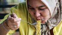 Warga menikmati mie instan di warung kopi (Warkop), Jakarta, Kamis (11/8/2022). Perang yang terjadi antara Rusia dan Ukraina berdampak pada naiknya harga mi instan. (Liputan6.com/Johan Tallo)