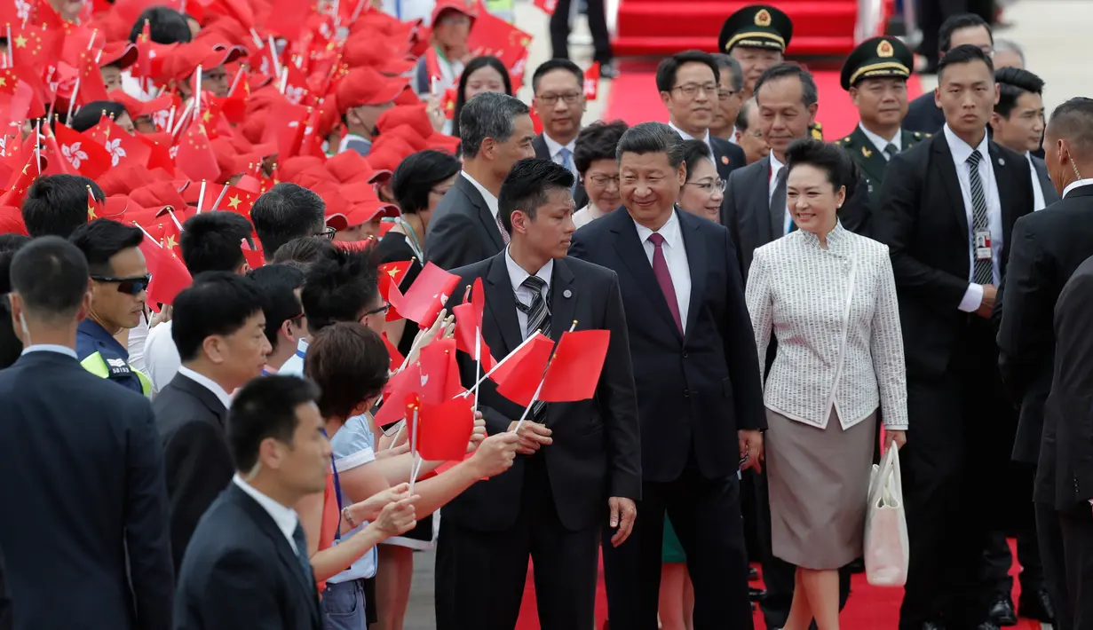 Presiden Cina Xi Jinping didampingi istri, Peng Liyuan setibanya di Bandara Internasional Hong Kong, Kamis (29/6). Kunjungan tersebut dilakukan dalam rangka memperingati 20 tahun penyerahan Hong Kong dari Inggris ke Cina. (AP Photo/Kin Cheung)