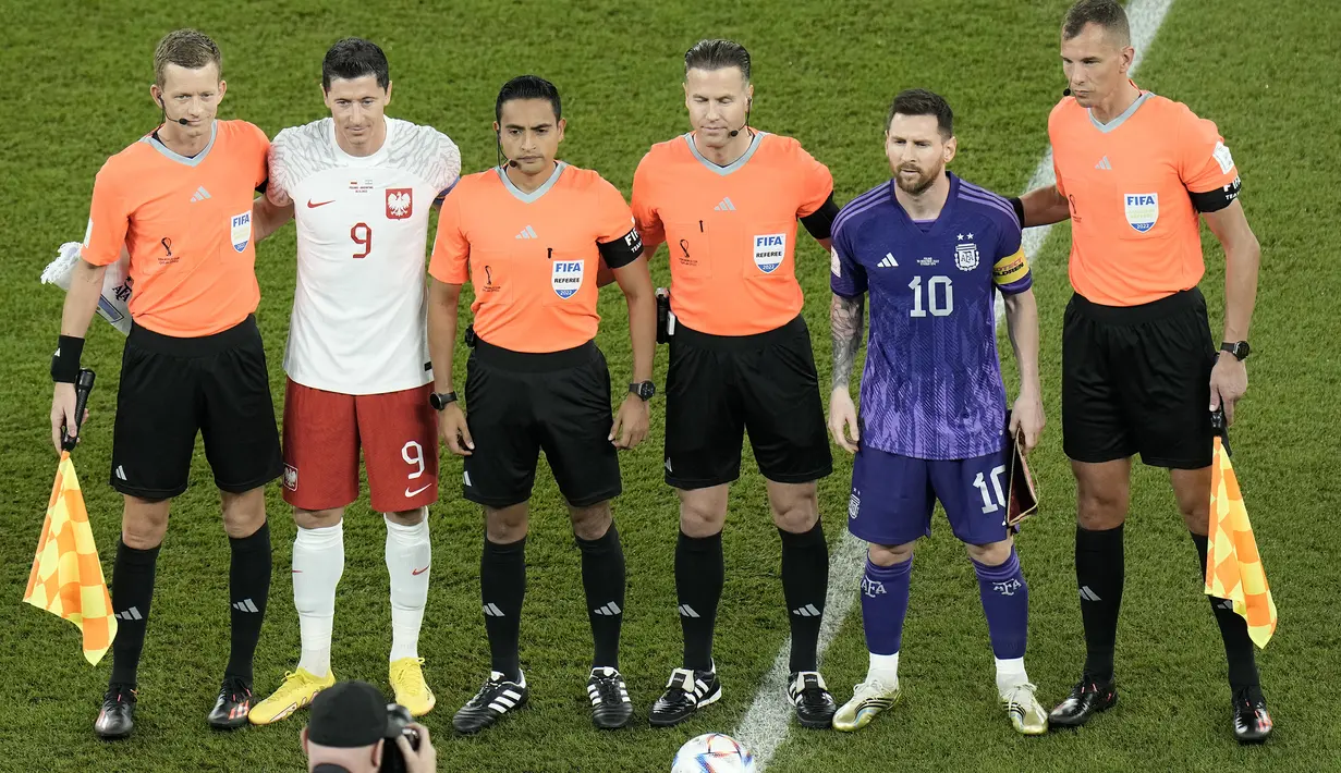 Sama-sama berstatus kapten tim, Lionel Messi dan Roobert Lewandowski saling memimpin timnya jelang kick-off pertandingan. Tampak keduanya saling respek satu sama lain sebagai perwakilan dua pesepak bola terbaik di dunia. (AP/Hassan Ammar)