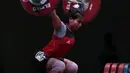 Sri Wahyuni berkonsentrasi mengangkat beban saat turun pada kelas 48 kg di Hall A Arena PRJ, Jakarta, Rabu (11/2/2018). Sri Wahyuni meraih medali emas dengan total angkatan 187 kg. (Bola.com/Nicklas Hanoatubun)