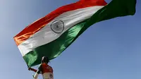 Supporter tim kriket India mengibarkan bendera kebangsaannya saat pertandingan melawan Sri Lanka di Galle, Sri Lanka, Kamis (13/8/2015). (Reuters/Dinuka Liyanawatte)