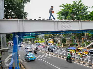Pekerja menyelesaikan pembangunan JPO di kawasan Tebet, Jakarta, Rabu (13/4). Saat ini warga tebet masih menyeberangi jalan raya dan baru 1 JPO yang tengah dibangun di sepanjang jalan Prof Dr Supomo, Tebet, Jakarta. (Liputan6.com/Yoppy Renato)