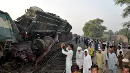 Seorang warga mengambil gambar salah satu gerbong yang terpental keluar jalur akibat tabrakan dua kereta api di Multan, Pakistan, Kamis (15/9). Insiden tersebut menewaskan sedikitnya 6 orang dan lebih dari 150 mengalami luka-luka. (REUTERS/Khalid Chaudry)