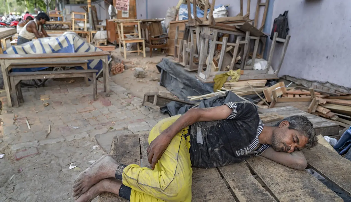 Seorang tukang kayu beristirahat di bawah naungan pohon pada sore musim panas di Prayagraj, di negara bagian Uttar Pradesh, India utara, Jumat (20/5/2022). Banyak bagian India mengalami kondisi gelombang panas dengan suhu di atas 45 derajat celsius ( 113 fahrenheit). (AP Photo/Rajesh Kumar Singh)