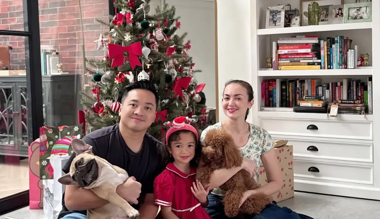 Rianti Cartwright merayakan Natal di rumah rumah bersama keluarga. Ia pun tampil santai dengan atasan lengan pendek motif floral dan rok denimnya. [@riantic]