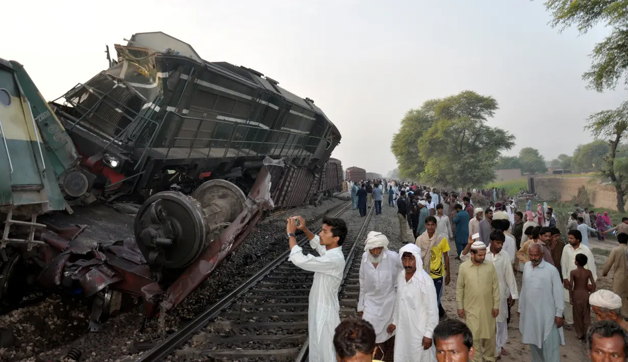 Seorang warga mengambil gambar salah satu gerbong yang terpental keluar jalur akibat tabrakan dua kereta api di Multan, Pakistan, Kamis (15/9). Insiden tersebut menewaskan sedikitnya 6 orang dan lebih dari 150 mengalami luka-luka. (REUTERS/Khalid Chaudry)