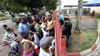 Para pengungsi Venezuela berdiri menunggu gerbang kantor perwakilan UNHCR di kota Boa Vista, negara bagian Roraima, Brasil (AFP/Evaristo Sa)