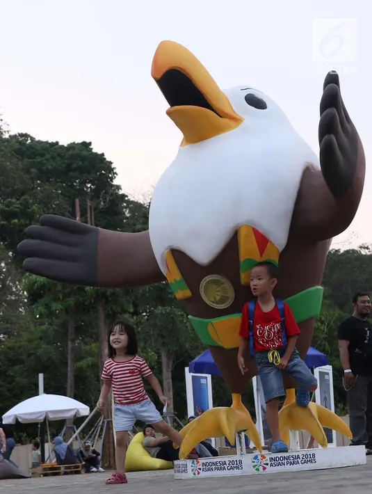 Dua orang anak berpose di depan maskot Asian Para Games 2018 di zona festival di Kompleks Stadion Gelora Bung Karno, Jakarta, Rabu (10/10). Zona ini dibuka seiring perhelatan Asian Para Games 2018, 6-13 Oktober. (Liputan6.com/Helmi Fithriansyah)