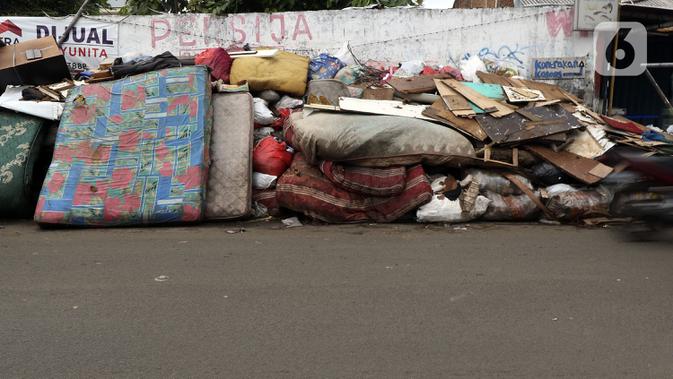 Tumpukan sampah terlihat menumpuk di sepanjang jalan pascabanjir mulai surut di kawasan Kembangan, Jakarta Barat, Minggu (5/1/2020). Pasca banjir yang melanda hampir di kawasan Jakarta mulai surut, tumpukan sampah terlihat di sepanjang jalan dari rumah-rumah warga. (Liputan6.com/Johan Tallo)