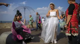Aktivis lingkungan berpakaian sampah kebanyakan dari plastik dalam unjuk rasa yang disebut Revolusi Mode di Tel Aviv, Israel, 19 November 2021. Aksi ini dilakukan untuk meningkatkan kesadaran iklim. (AP Photo/Oded Balilty)