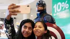 Dua penggemar wanita berselfie di dekat patung Captain America saat mengantre untuk menyaksikan pemutaran perdana film The Avengers: Endgame di La Paz, Bolivia (24/4). Film Avengers ini diputar perdana secara serentak pada 24 April 2019. (Reuters/David Mercado)