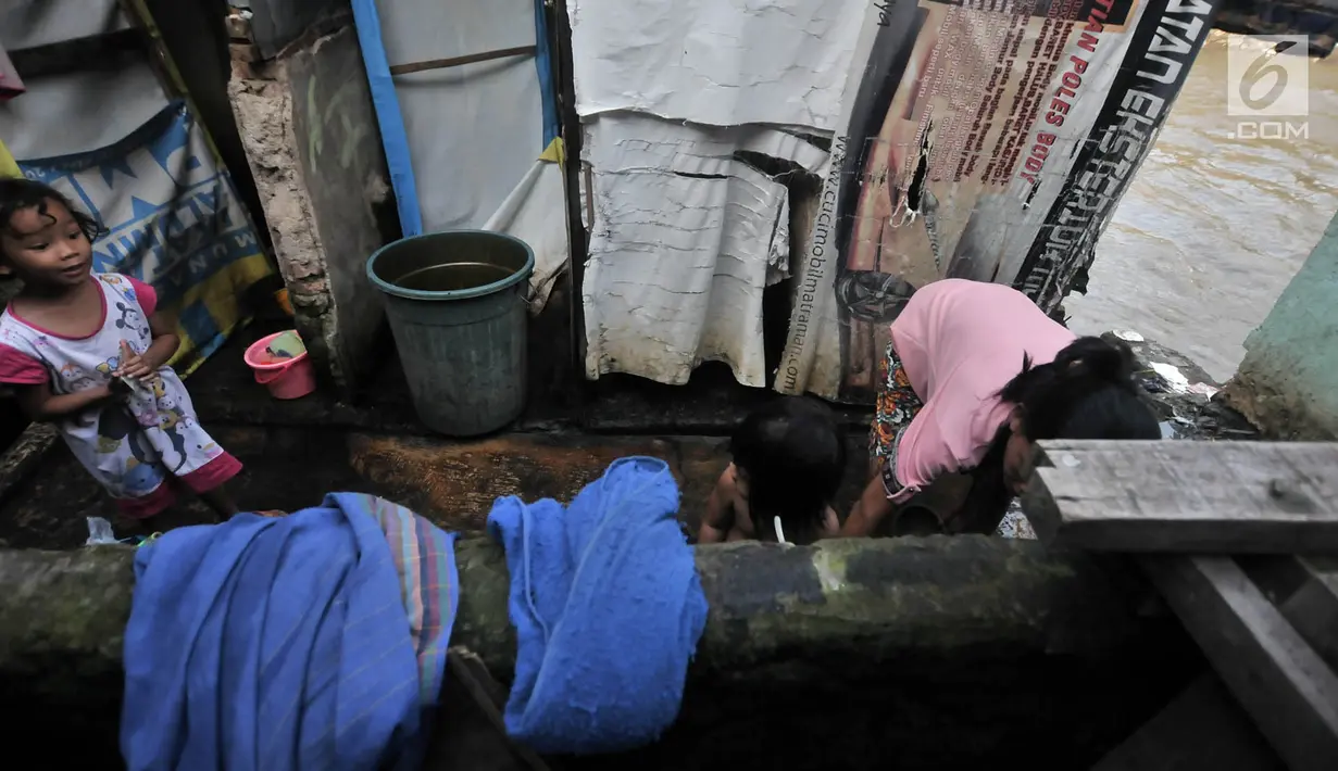Anak-anak mandi di toilet umum kawasan bantaran Kali Ciliwung, Jakarta, Senin (19/11). Tak adanya akses sanitasi yang layak menyebabkan anak-anak menderita stunting. (Merdeka.com/Iqbal Nugroho)