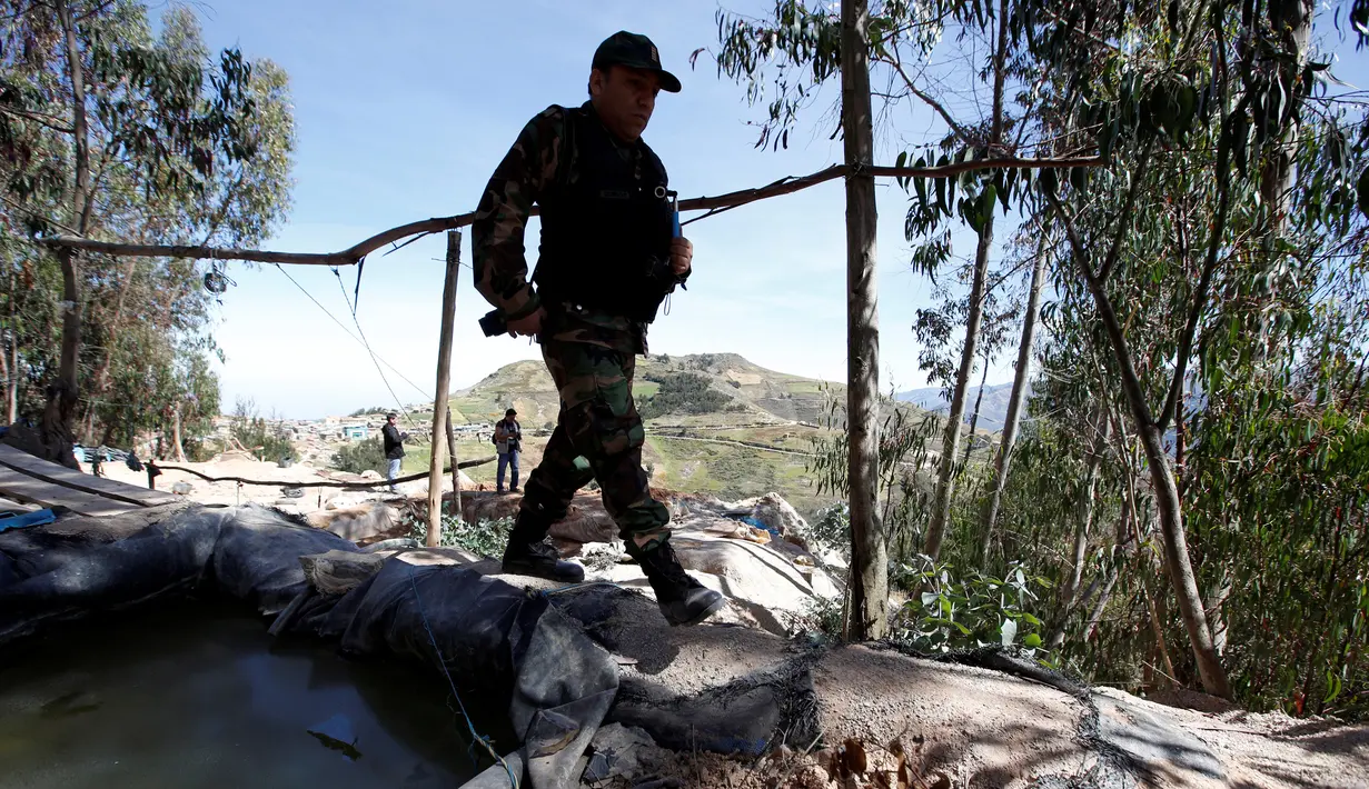 Polisi Peru berjalan di kamp pertambangan emas ilegal di Salpo, Pegunungan Andes, La Libertad (25/5). Aksi ini untuk memberantas penambang-penambang emas ilegal yang masih menyebar di sekitar Pegunungan Andes. (REUTERS / Mariana Bazo)