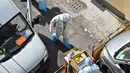 Petugas kesehatan yang mengenakan alat pelindung diri bekerja di jalan saat lockdown tahap kedua akibat COVID-19 di Distrik Jing'an, Shanghai, China, Rabu (6/4/2022). (Hector RETAMAL/AFP)