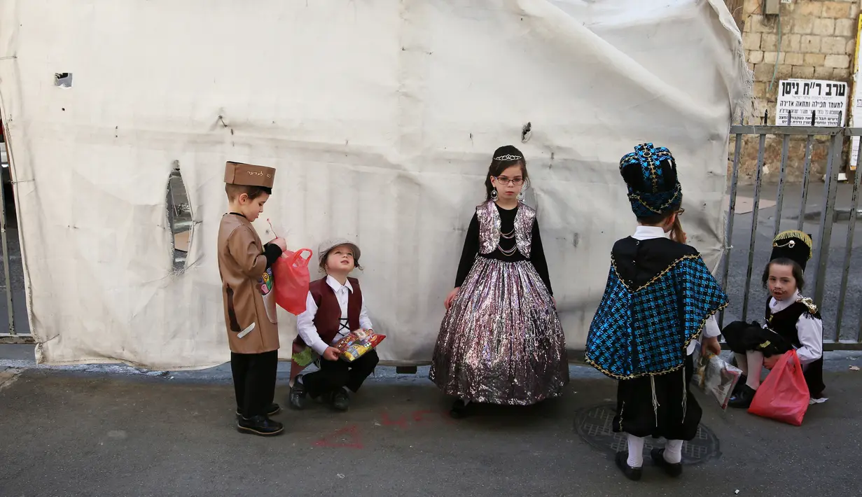 Anak-anak Yahudi ultra-Ortodoks mengenakan kostum lengkap dengan atributnya bersiap mengikuti perayaan purim di Yerusalem (8/3). Perayaan Purim ini dimulai pada saat matahari terbenam. (AFP/Menahem Kahana)