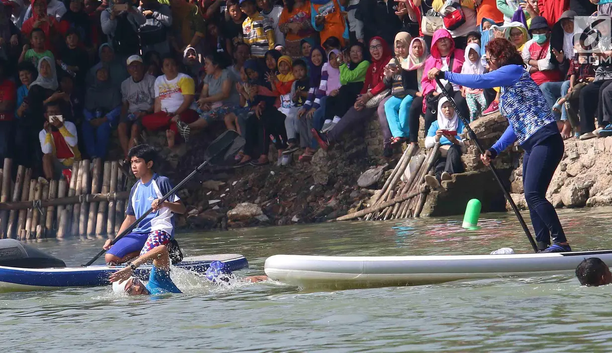Menteri KKP Susi Pudjiastuti dan Wagub DKI Jakarta Sandiaga Uno bertanding selama Festival Danau Sunter, Jakarta, Minggu (25/2). Pertandingan ini menjadi daya tarik masyarakat yang ingin melihat kedua tokoh tersebut bertanding. (Liputan6.com/Angga Yuniar)