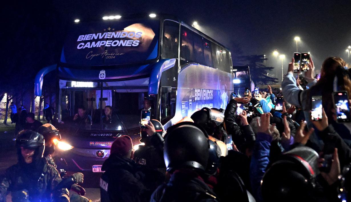 Para penggemar mengambil gambar bus yang mengangkut tim sepak bola nasional Argentina di Ezeiza, Buenos Aires, Argentina pada 15 Juli 2024. (Luis ROBAYO/AFP)
