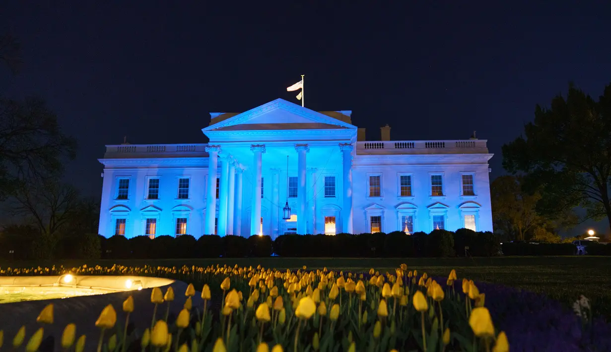 Gedung Putih menyala dengan warna biru untuk menandai World Autism Awareness Day atau Hari Peduli Autisme Sedunia di Washington, Kamis (2/4/2020). Hari Peduli Autisme Sedunia jatuh setiap 2 April semenjak ditetapkan melalui sebuah resolusi PBB di tahun 2007. (MANDEL NGAN / AFP)