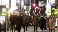 Orang-orang memakai masker untuk melindungi dari penyebaran virus corona berjalan di sepanjang jalan yang dipenuhi bar dan restoran di Tokyo, Rabu (19/1/2022). Tokyo dan puluhan daerah lain di Jepang akan menghadapi pembatasan COVID-19 baru yang berlaku efektif Jumat (21/1). (AP Photo/Koji Sasahara)