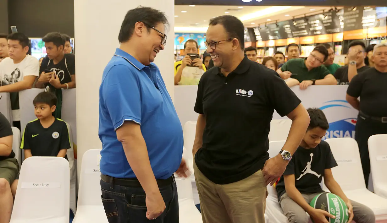 Gubernur DKI Jakarta Anies Baswedan berbincang dengan Ketum Partai Golkar sekaligus Menteri Perindustrian Airlangga Hartarto di Pluit Village Mall, Jakarta, Minggu (29/7). Anies dan Airlangga tampak mengenakan kaos. (Liputan6.com/Fery Pradolo)