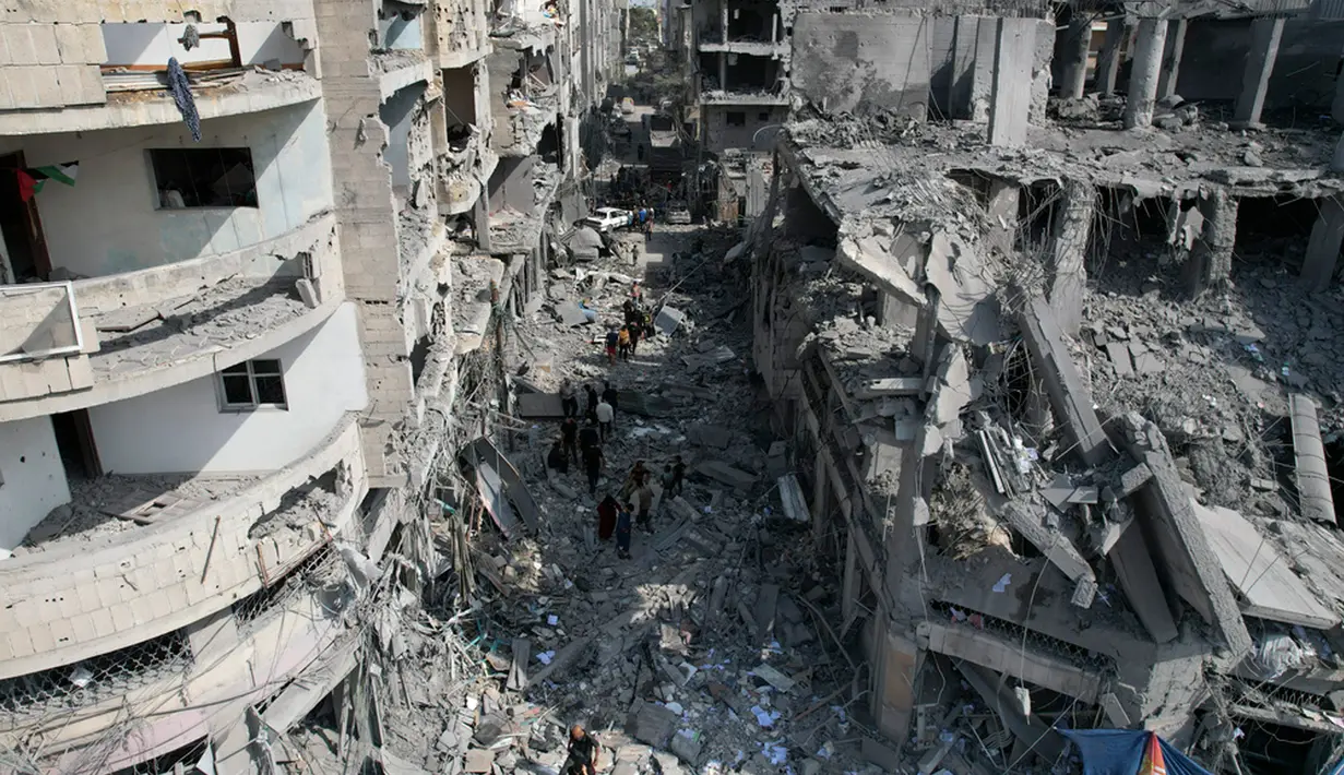 Warga mencari korban selamat pascabombardir Israel di Deir Al-Balah, Jalur Gaza, Palestina, Minggu (22/10/2023). (AP Photo/Hatem Moussa)
