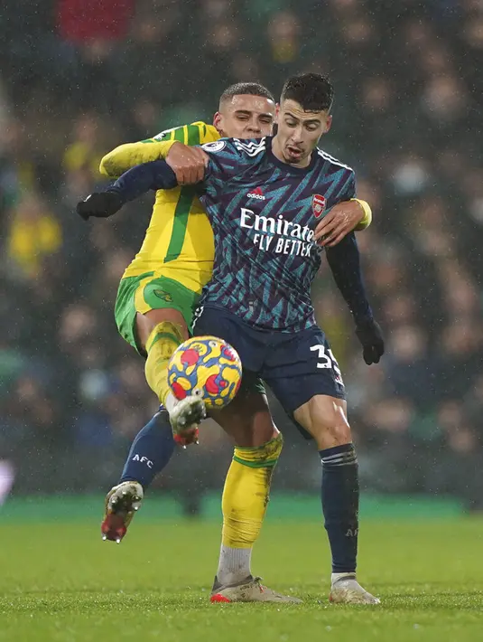 Pemain Norwich City Max Aarons (kiri) dan pemain Arsenal Gabriel Martinelli berebut bola pada pertandingan sepak bola Liga Inggris di Stadion Carrow, Norwich, Inggris, Minggu (26/12/2021). Arsenal menang 5-0. (Joe Giddens/PA via AP)