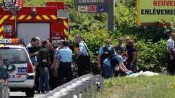 Petugas kepolisian di Gonesse, utara Paris melakukan olah TKP dimana seorang gangster terkenal Prancis, Redoine Faid meninggalkan helikopternya setelah kabur dari penjara di Reau, Minggu (1/7). (AFP/GEOFFROY VAN DER HASSELT)