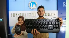 Dua siswa menunjukkan mouse dan keyboard Logitech di SMA Al-Azhar 2 Pejaten, Jakarta, Rabu (14/8/2019). Logitech berkomitmen untuk mendukung kemajuan eSport di Indonesia dengan memberikan peralatan gaming Logitech G dengan harapan mampu melahirkan atlet eSport yang berbakat. (Liputan6.com/HO/Ady)