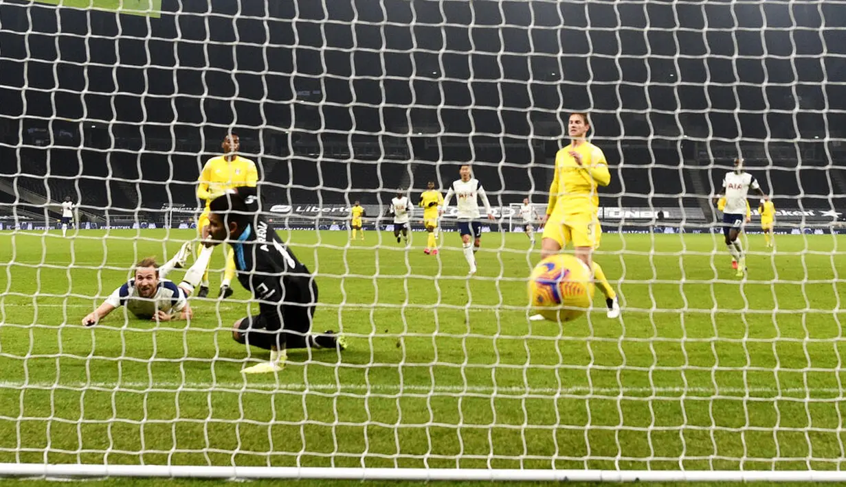Pemain Tottenham Hotspur Harry Kane (kiri) mencetak gol ke gawang Fulham pada pertandingan Liga Inggris di Stadion Tottenham Hotspur, London, Inggris, Rabu (13/1/2021). Pertandingan berakhir dengan skor 1-1. (Shaun Botterill/Pool via AP)