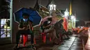 Orang-orang menggunakan ponsel mereka saat antre semalaman untuk tes swab Covid-19 gratis di Wat Phra Sri Mahathat Woramahawihan di Bangkok, Jumat (9/7/2021) dinihari. Thailand pada Kamis (8/7/2021), mencatat rekor 75 kematian Covid-19 dalam 24 jam terakhir. (Lillian SUWANRUMPHA/AFP)