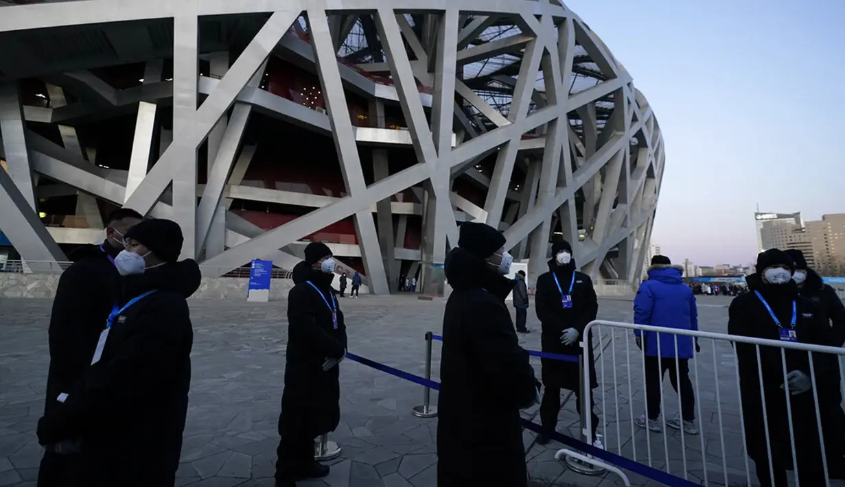 Penjaga keamanan berdiri di luar Stadion Nasional yang dikenal sebagai Sarang Burung jelang upacara pembukaan Olimpiade Musim Dingin 2022 di Beijing, China, Jumat (4/2/2022). Upacara pembukaan Olimpiade Musim Dingin 2022 akan digelar malam ini. (AP Photo/Jae C.Hong)