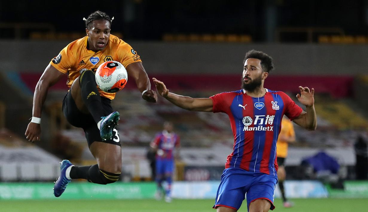 Gelandang Wolverhampton Wanderers, Adama Traore, berebut bola dengan gelandang Crystal Palace, Andros Townsend, pada laga lanjutan Premier League di Molineux Stadium, Selasa (21/7/2020) dini hari WIB. Wolves menang 2-0 atas Crystal Palace. (AFP/Martin Rickett/pool)