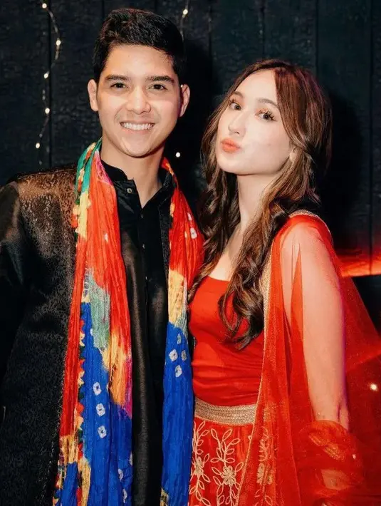 Laura Moane tampil mencolok dengan kain sari merah. Sementara Al-Ghazali tampil lebih netral dengan busana hitam dan kain warna-warni [@allaura_shipper]