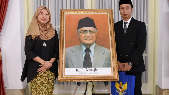 Keluarga KH Masjkur berfoto di samping lukisannya usai penganugerahan gelar Pahlawan Nasional