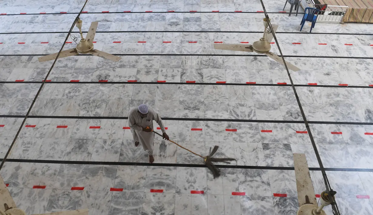 Umat Muslim menyapu lantai sebuah masjid menjelang Ramadan selama penguncian nasional yang diberlakukan pemerintah sebagai langkah pencegahan terhadap coronavirus COVID-19, di Karachi, Pakistan (21/4/2020). (AFP/Asif Hassan)