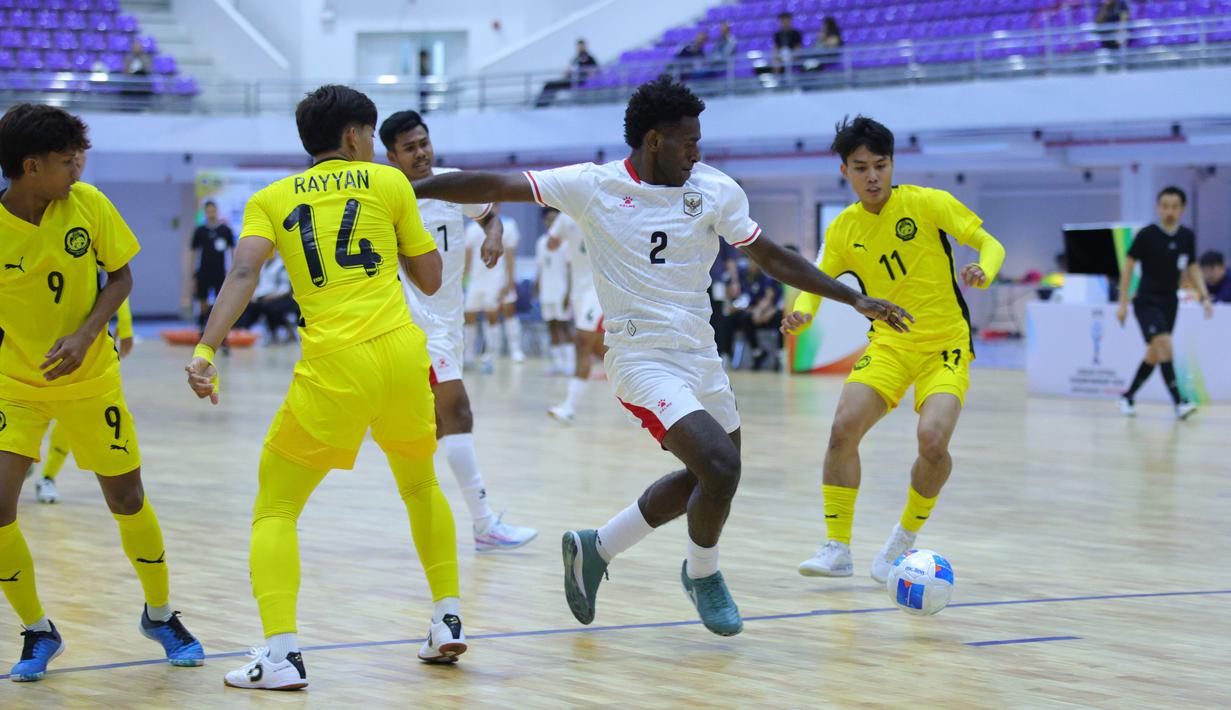 Pemain Timnas Futsal Indonesia, Cris Daniel mencoba melawati pemain Malaysia di Piala AFF Futsal 2026 yang bertempat di Nonthaburi Sports Complex Gymnasium, Thailand, Selasa (7/4/2026). (Dok. FFI)