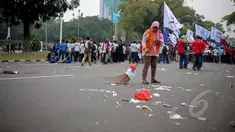Petugas kebersihan membersihkan sampah saat peringatan hari buruh sedunia yang jatuh pada tanggal 1 Mei di depan Istana Merdeka, Jakarta, Jumat (1/5/2015). Aksi demo May Day menyisahkan sejumlah sampah berserakan di jalan. (Liputan6.com/Faizal Fanani)