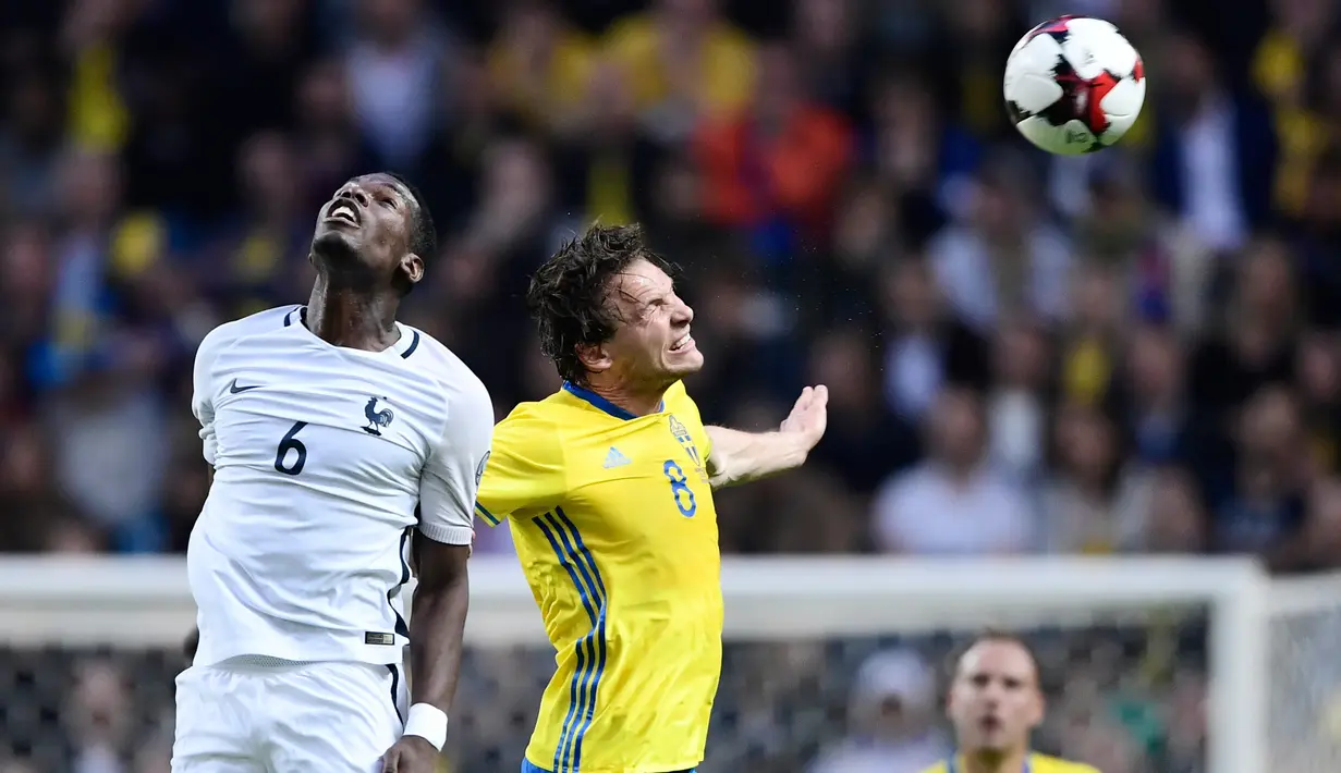 Gelandang Prancis, Paul Pogba berebut bola udara dengan gelandang Swedia, Albin Ekdal saat bertanding pada kualifikasi Piala Dunia 2018 di Friends Arena, Solna, Stockholm (9/6). Swedia menang atas Prancis dengan skor 2-1. (Marcus Eriksson/TT via AP)