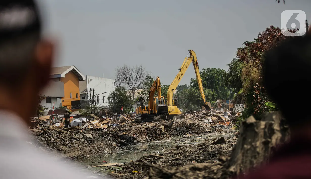 Warga melihat pembongkaran bangunan liar yang berada di dekat kali kecil di kawasan Jalan Agung Perkasa VIII Sunter, Jakarta, Senin (18/11/2019). Pembongkaran tersebut ditujukan untuk menciptakan tata ruang ramah lingkungan dan sehat. (Liputan6.com/Faizal Fanani)