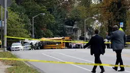 Pejabat setempat meninjau lokasi kecelakaan antara bus komuter dengan bus sekolah di Baltimore, Maryland, Selasa (1/11). Hingga saat ini, otoritas berwenang di Baltimore belum memberikan informasi terkait penyebab kecelakaan. (AP Photo/Patrick Semansky)